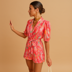 Short summer jumpsuit for women with vibrant print and belted waist, perfect for warm days, evening outings, and stylish summer occasions.